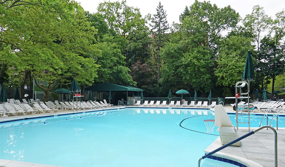A close up image of a pool with surrounding pool chairs 
